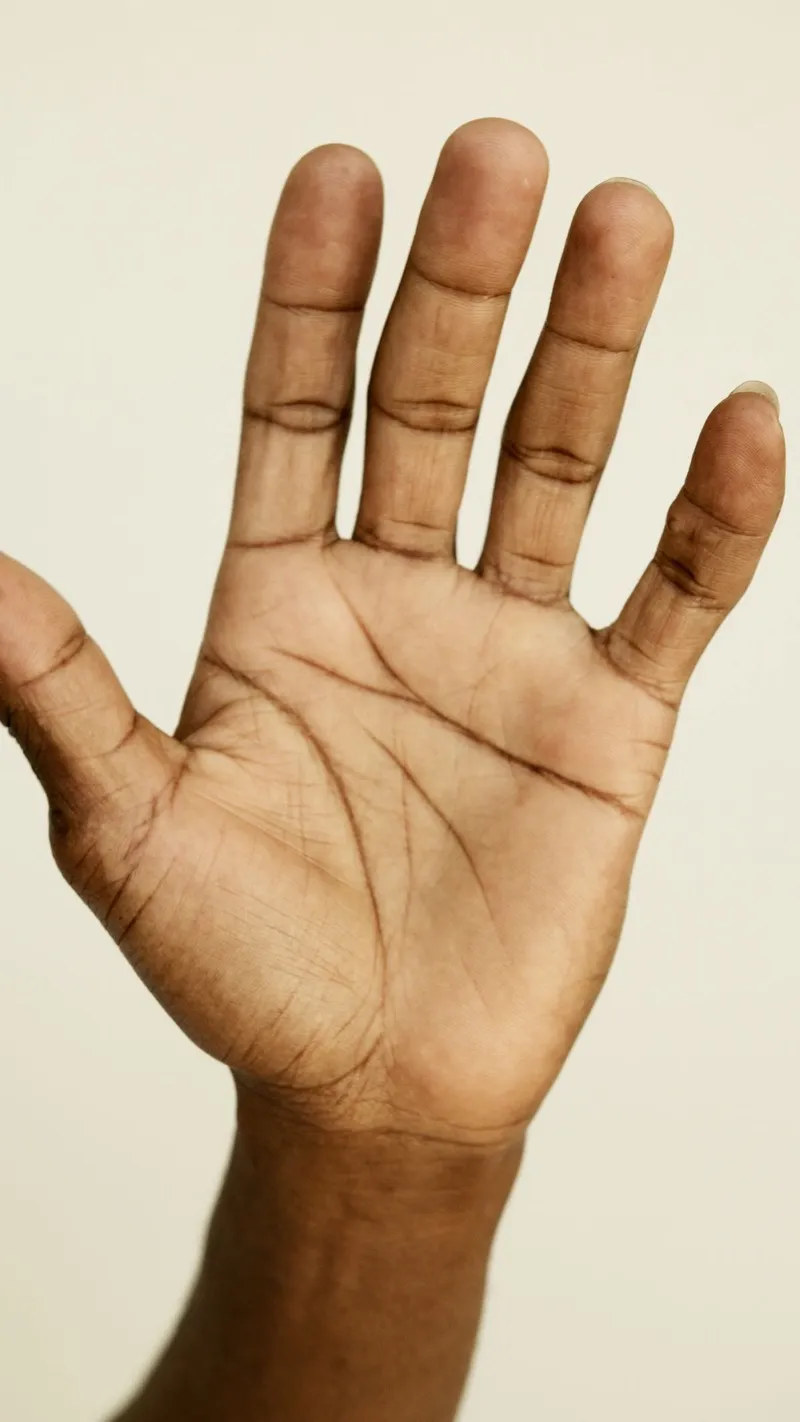 Photograph of an open right palm with visible life, heart, and head lines, used as a reference diagram for palmistry.